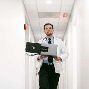 Dr. walking down a hospital hallway while holding a sidetrak swivel portable monitor