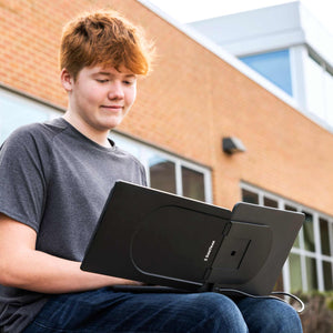 Student working in a school courtyard with his SideTrak portable monitor.