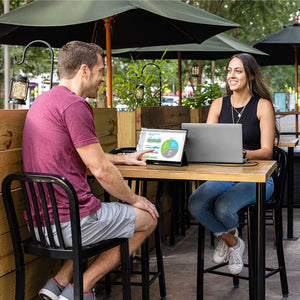 People collaborating at a café with SideTrak Solo portable monitors. 
