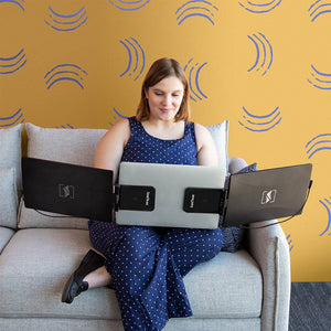 12.5" | Swivel | Sidetrak | Triple | Hub | Multi Monitor Setup | woman working on a 12.5 swivel triple monitor with hub on a couch